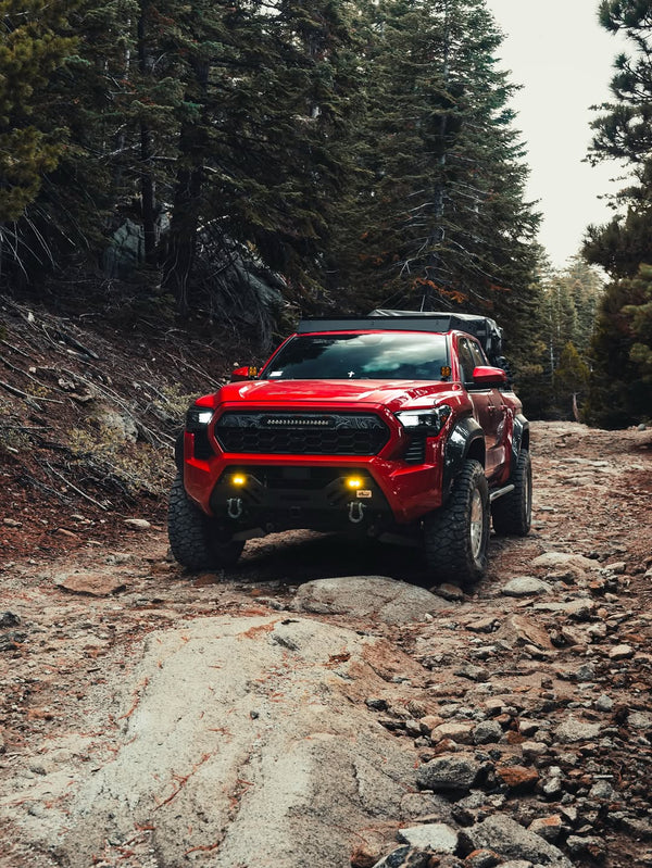 Red 2024 Tacoma with Apex Pro grille on a trail