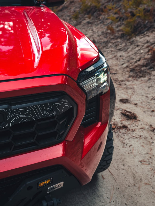 Close-up of Apex Pro grille on a red Tacoma